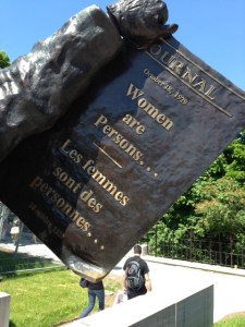 The plaque that the woman in the sculpture is holding up, which is the front page of a newspaper when the ruling was announced