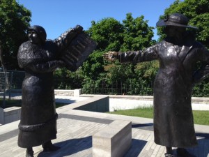 Two of the women in the sculpture commemorating the court ruling - one holding up the front page of a newspaper to three other women in the sculpture