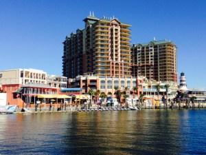 The harbor front as you turn off the Intracoastal into the narrow mouth of Destin Harbor - it is clearly a destination resort harbor with waterfront restaurants, bars, shops, etc. lining the waterfront, and a beautiful Gulf-front dune beach across the harbor