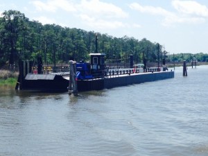 When the "bow thruster" swings the bow into the river, the floating bridge pivots on the post at the other end. When it swings all the way around perpendicular to the river, the "bow is secured to the other shore and vehicles can then cross on the floating bridge.