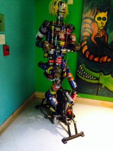 A man on a treadmill, built from old coffee cans -